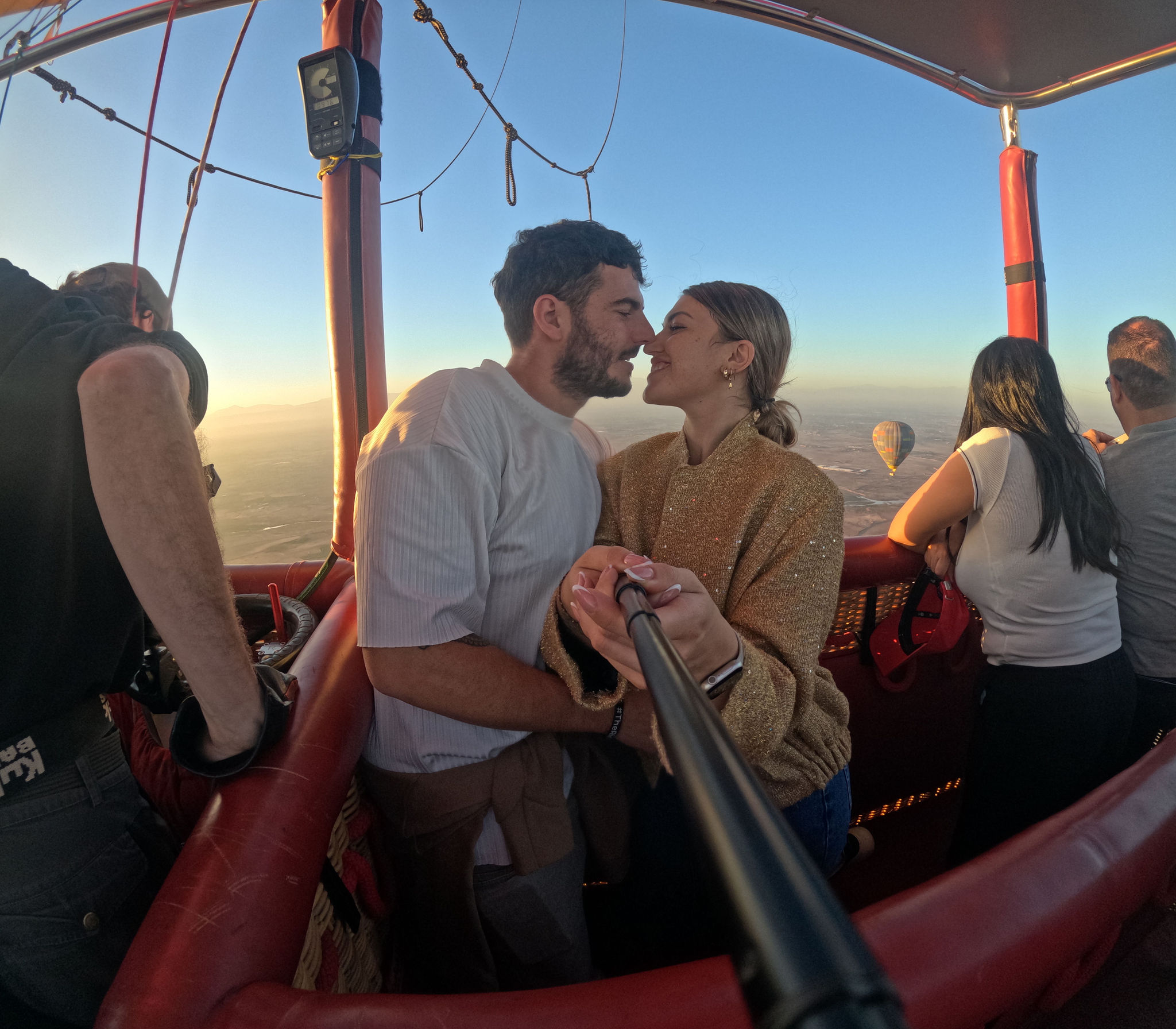 Guests in a hot air balloon basket at sunrise over the Marrakech countryside
