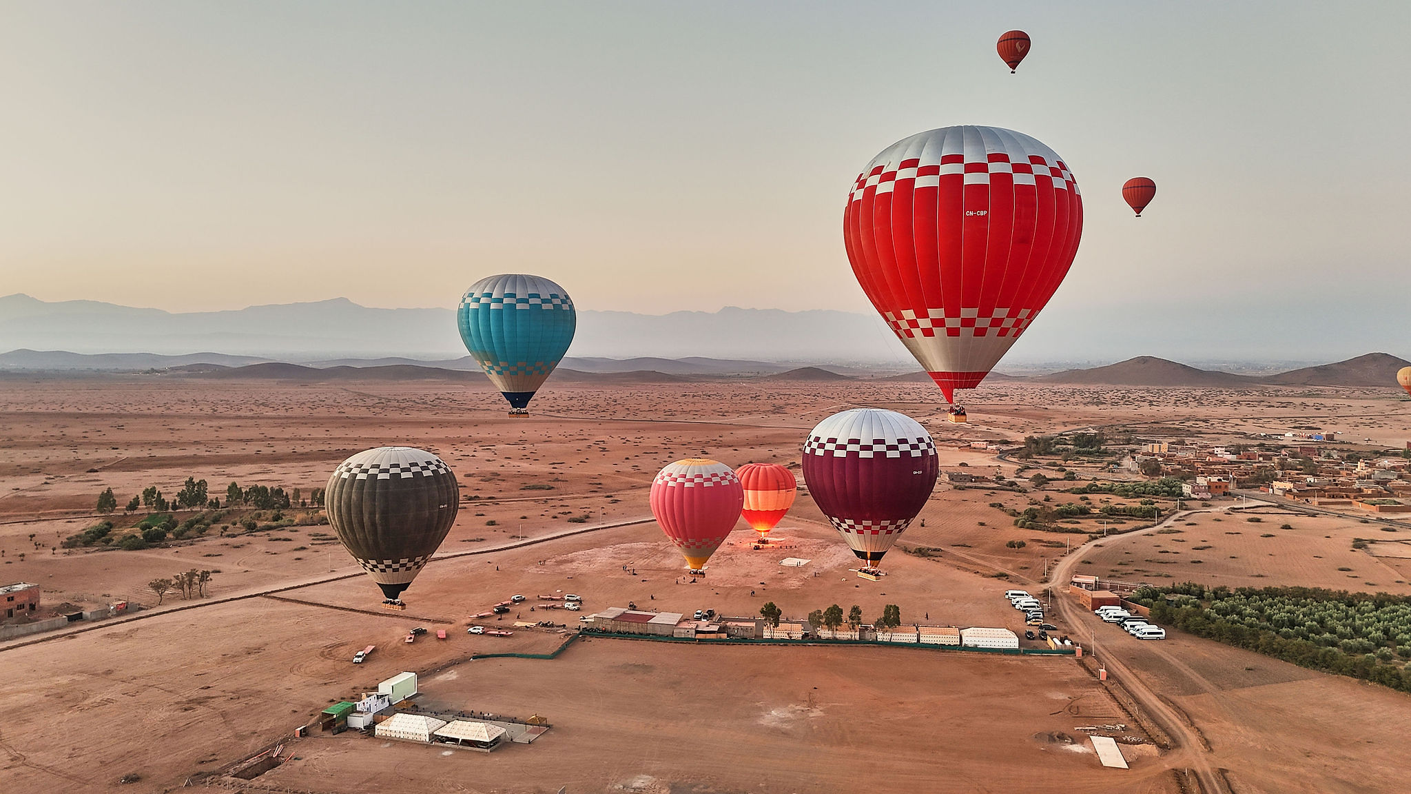 Aerial view of balloons inflating and lifting off from the launch field outside Marrakech