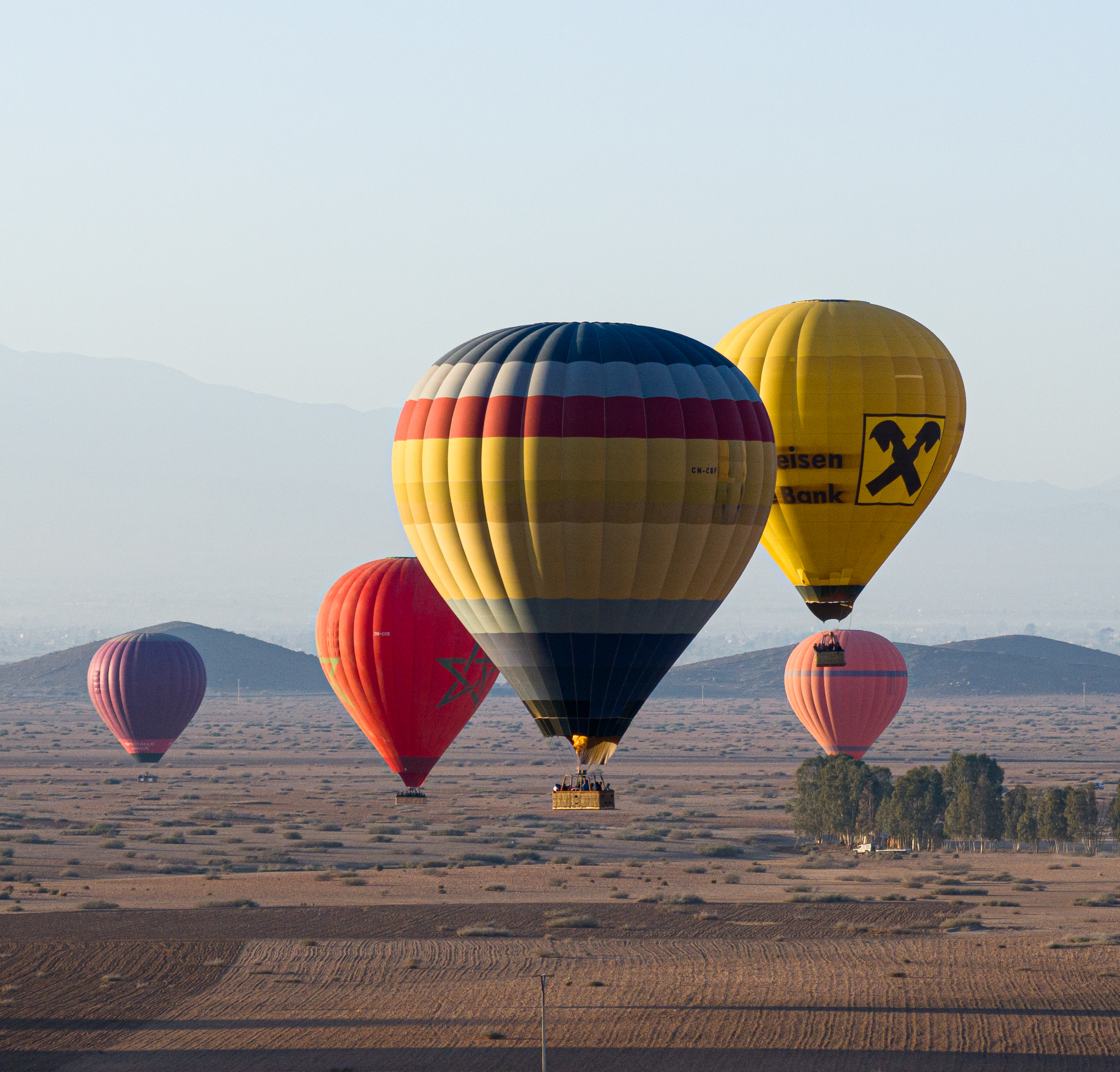 Balloons drifting in morning haze over the plain outside Marrakech