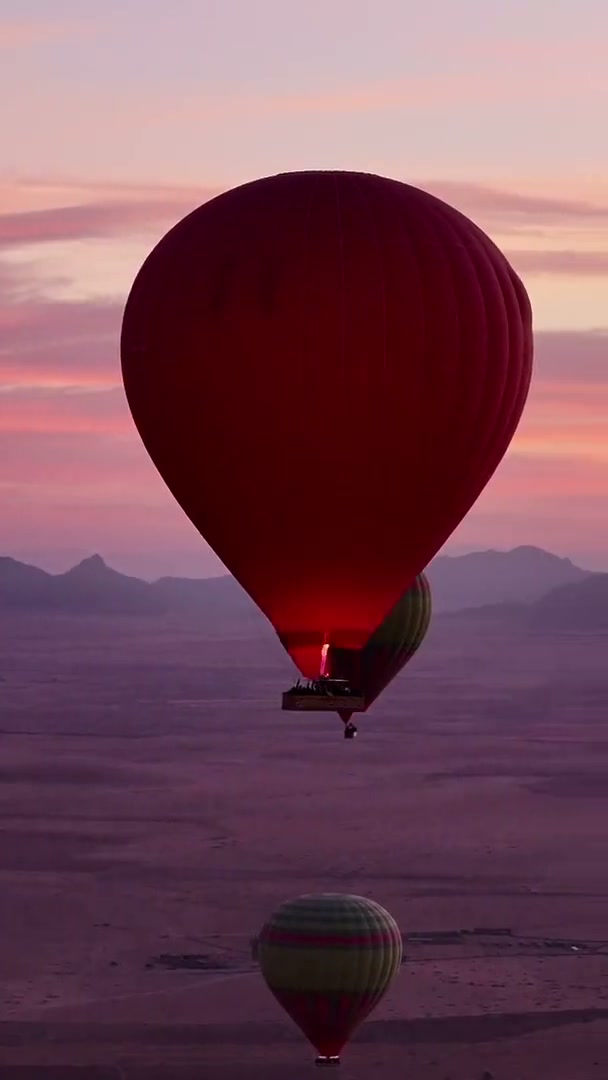 Cinematic sunrise cuts of balloons launching and silhouettes over the plain