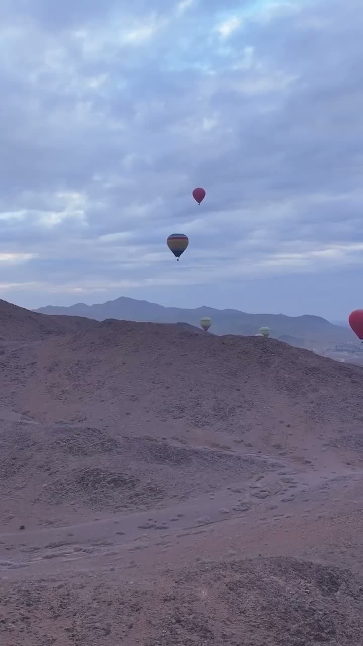 A red balloon over the Atlas at sunrise with a full basket of passengers