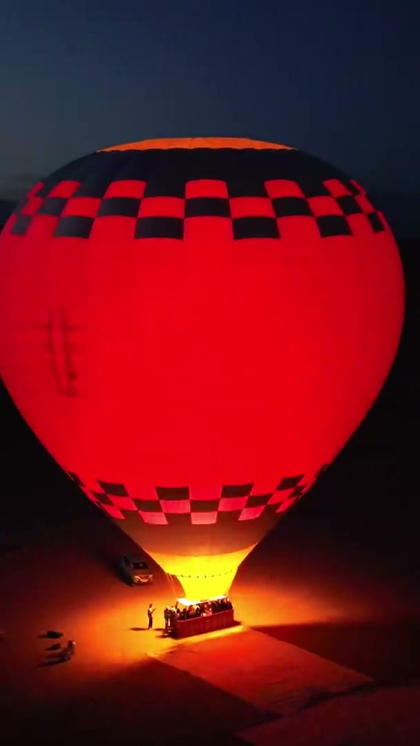 Night glow on the launch field, then a yellow balloon over the desert at dawn