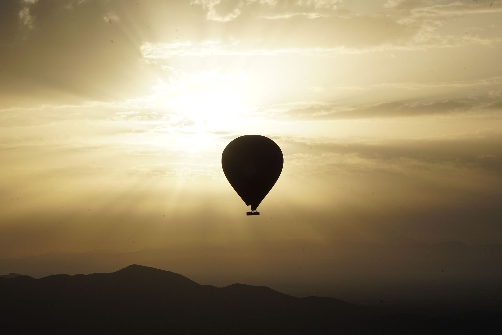 A balloon in silhouette against the sunrise over the Atlas