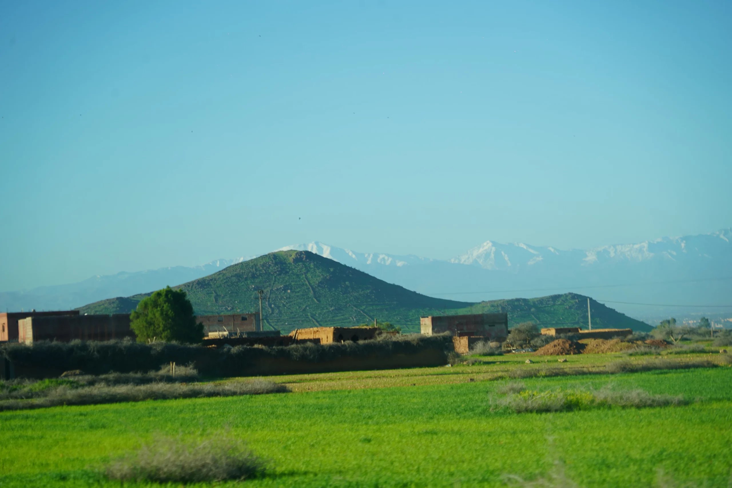 Atlas peaks and green fields on the plain outside Marrakech